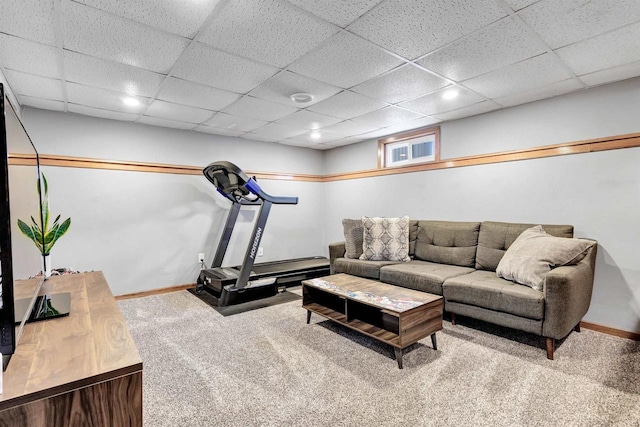 living area with a paneled ceiling, baseboards, and carpet