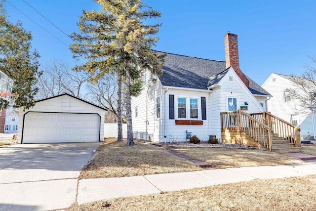 view of front of home with a garage, a chimney, an outdoor structure, and a shingled roof