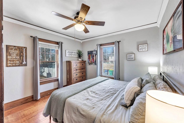 bedroom featuring a ceiling fan, light wood-type flooring, baseboards, and ornamental molding