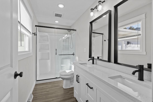 bathroom with visible vents, a shower stall, toilet, and a sink