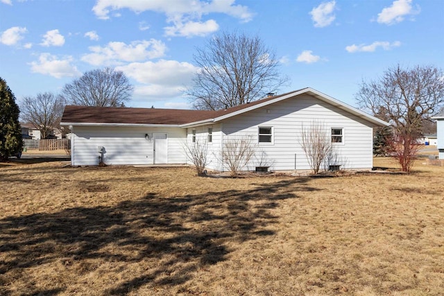 rear view of house featuring a lawn