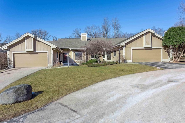 view of front facade with a front lawn, a garage, and driveway