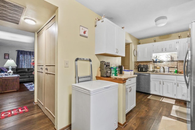 kitchen with dark wood finished floors, white cabinets, visible vents, and appliances with stainless steel finishes