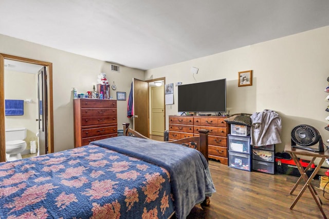 bedroom featuring dark wood-style floors, visible vents, and connected bathroom