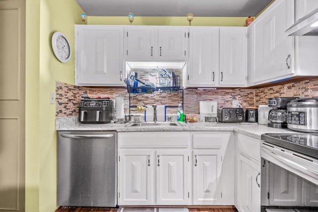 kitchen with white cabinetry, stainless steel appliances, wall chimney range hood, and a sink