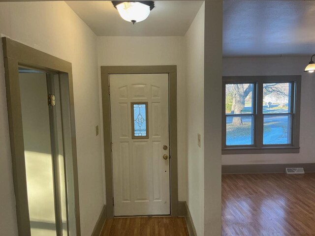 entrance foyer featuring wood finished floors, visible vents, and baseboards