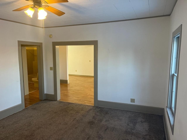 carpeted spare room with baseboards and crown molding