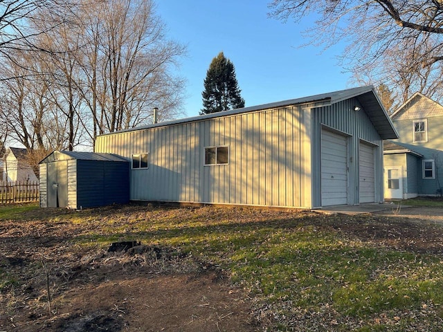 exterior space with a detached garage, an outdoor structure, and fence