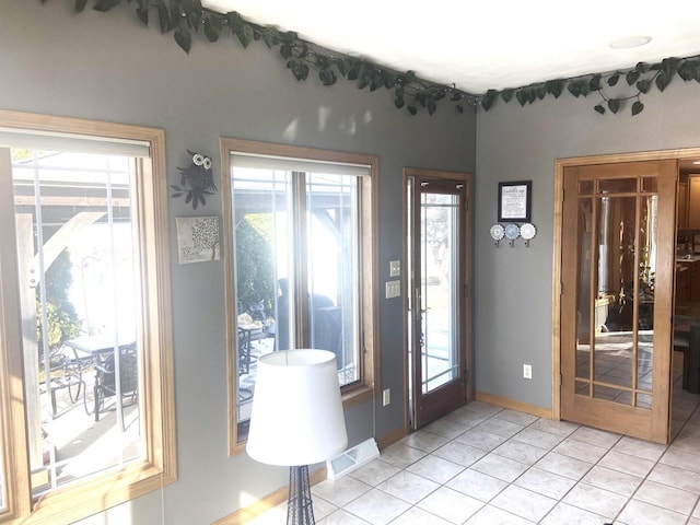 entryway with light tile patterned floors, baseboards, and visible vents