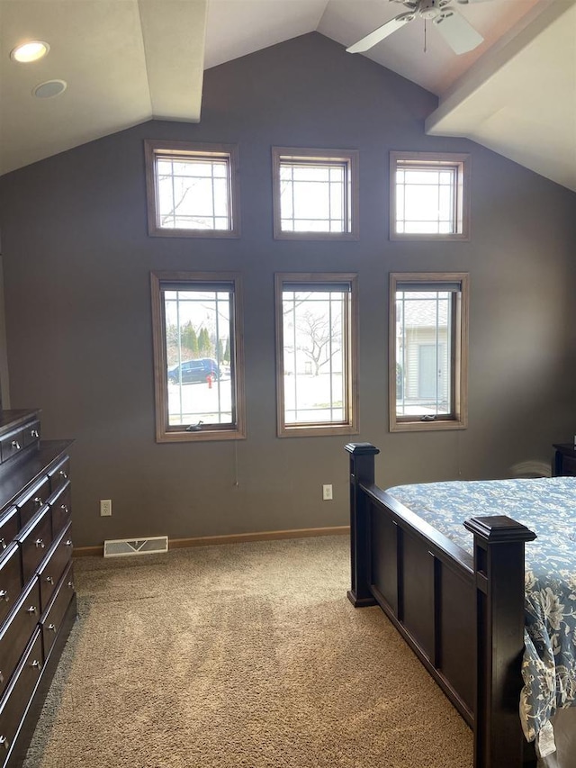 carpeted bedroom with baseboards, multiple windows, and vaulted ceiling