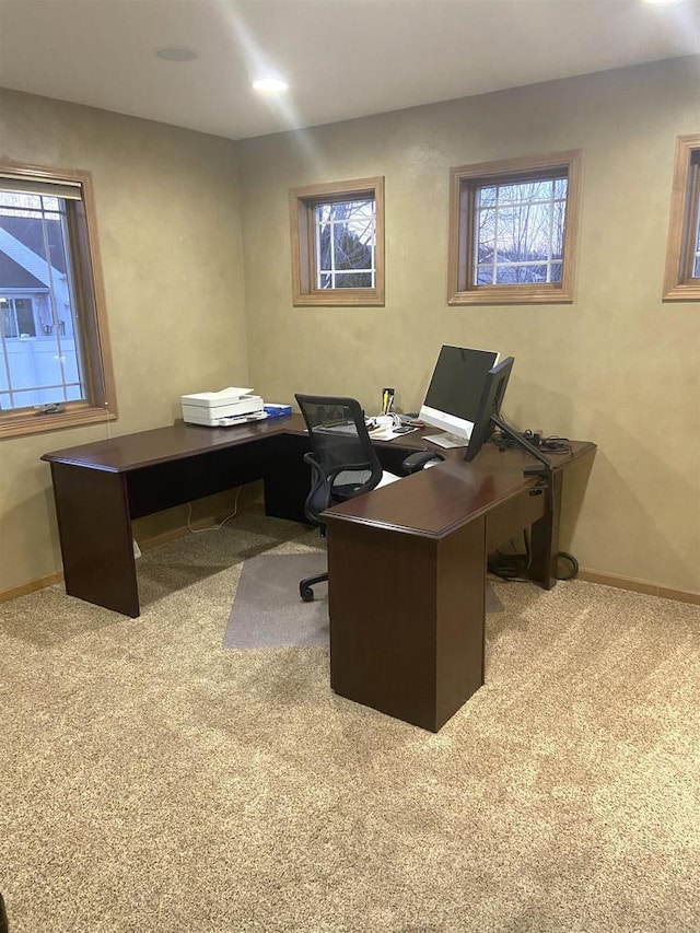 carpeted office with a healthy amount of sunlight and baseboards