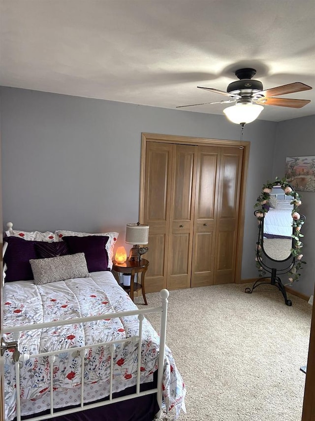 carpeted bedroom with a ceiling fan and a closet