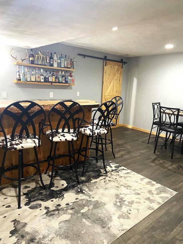 bar featuring recessed lighting, baseboards, a barn door, and wood finished floors