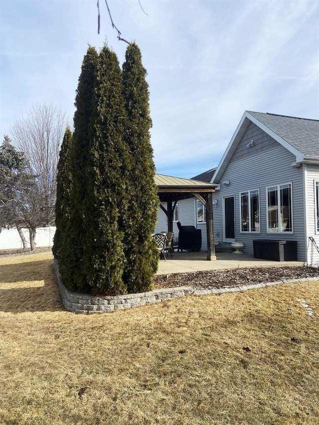 rear view of house featuring a gazebo, a yard, and a patio