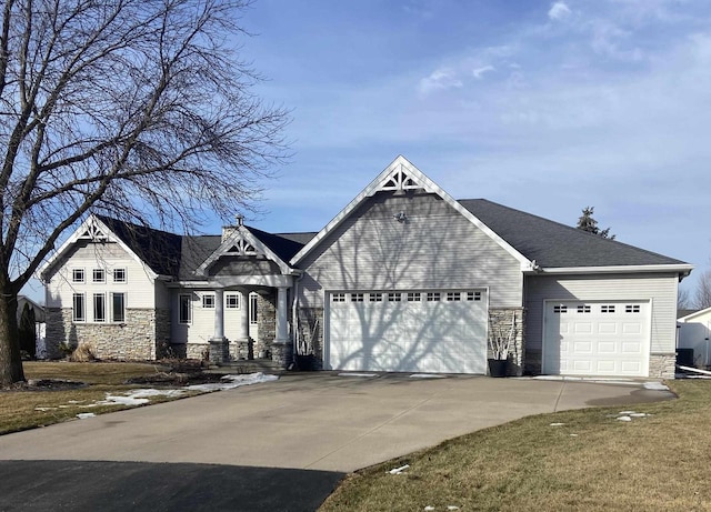 view of front of property with a garage, stone siding, and driveway