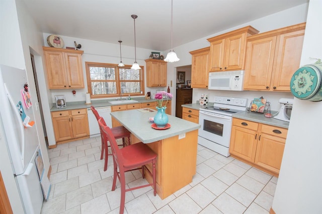 kitchen with a sink, a kitchen breakfast bar, a center island, white appliances, and light countertops