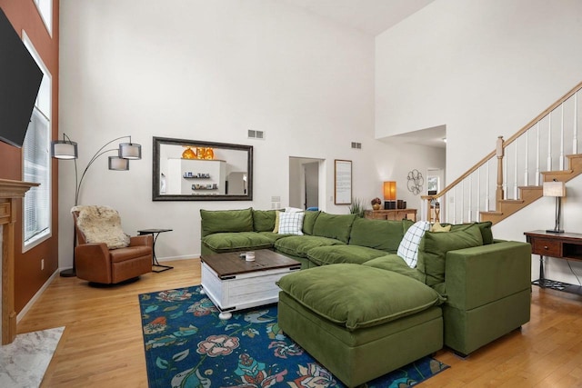 living area featuring stairway, visible vents, and wood finished floors