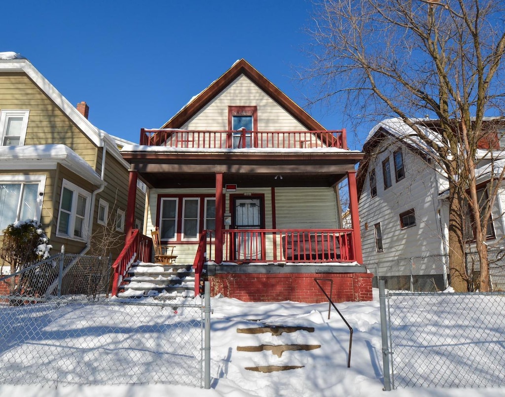 view of front of property featuring a fenced front yard, covered porch, and a gate