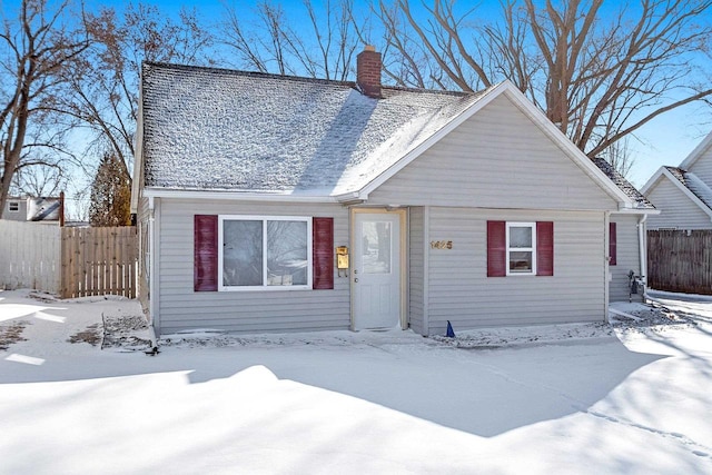 view of front of house featuring a chimney and fence