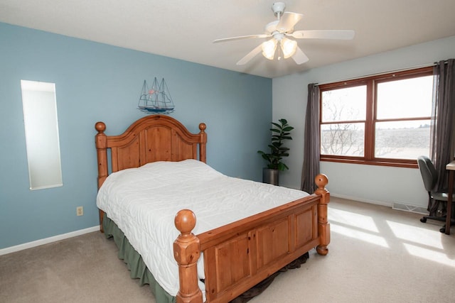 bedroom featuring visible vents, light colored carpet, baseboards, and ceiling fan