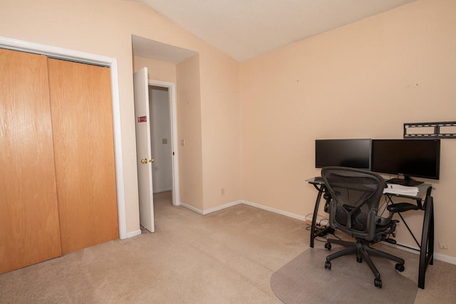 carpeted office space featuring baseboards and lofted ceiling