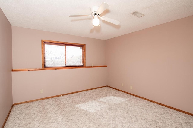 carpeted empty room featuring visible vents, a ceiling fan, baseboards, and a textured ceiling