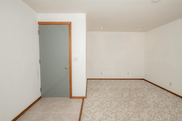 empty room featuring light tile patterned floors and baseboards