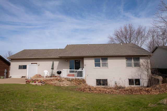 back of property with a lawn and a shingled roof