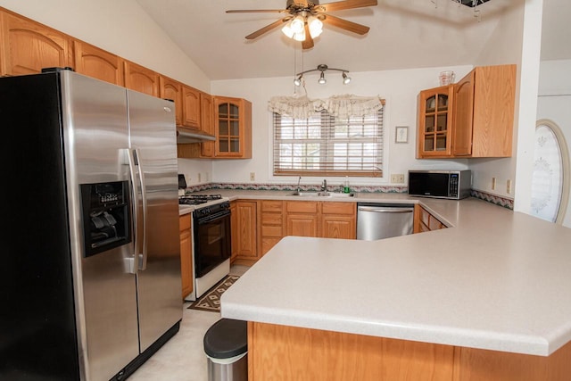 kitchen with a sink, stainless steel appliances, glass insert cabinets, and a peninsula