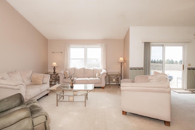 carpeted living area featuring vaulted ceiling