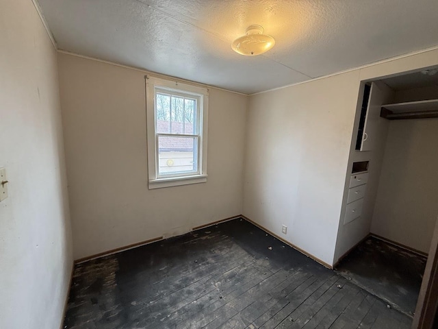 unfurnished bedroom with dark wood-type flooring and a textured ceiling