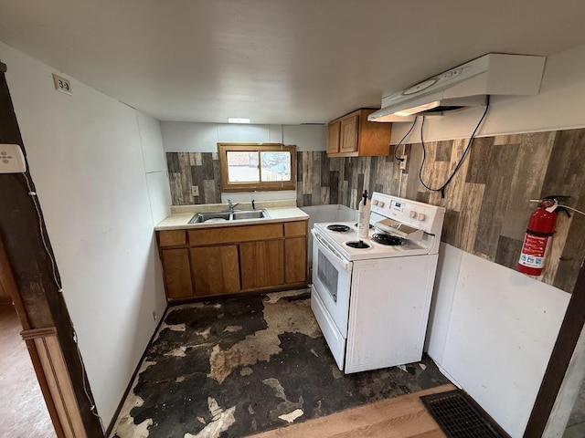 kitchen featuring white range with electric cooktop, under cabinet range hood, light countertops, brown cabinets, and a sink