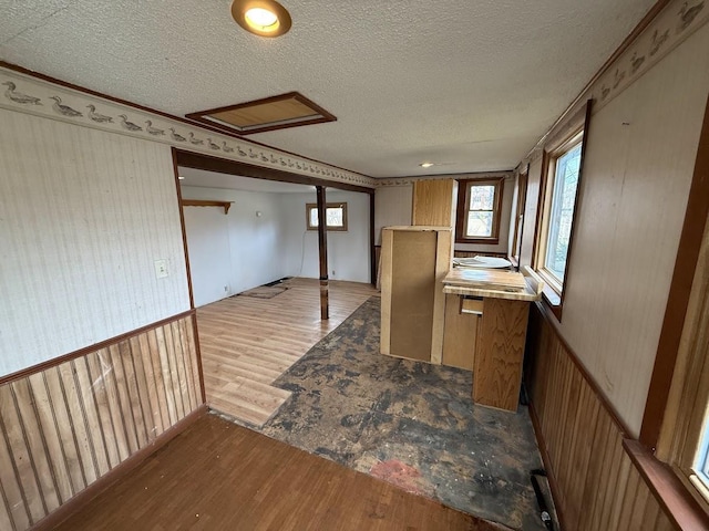 kitchen with brown cabinets, a textured ceiling, and wood finished floors