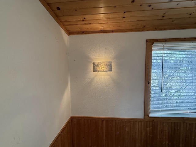 room details featuring wooden walls, wainscoting, and wood ceiling