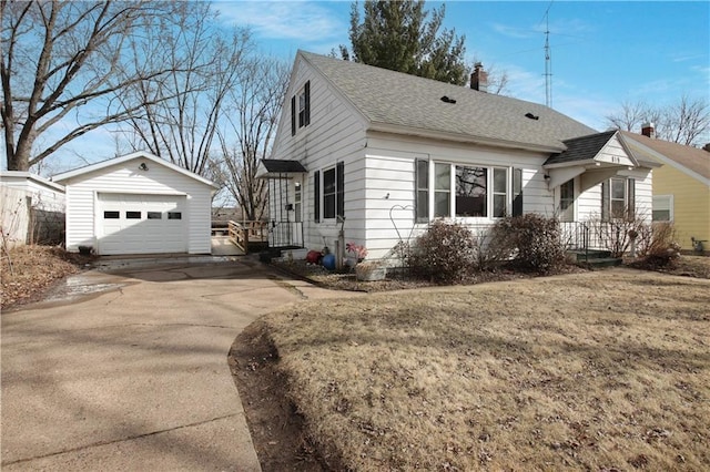 view of side of home with an outbuilding, concrete driveway, a garage, and a shingled roof