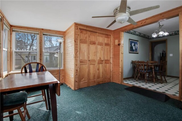 dining space with ceiling fan with notable chandelier, baseboards, and carpet floors
