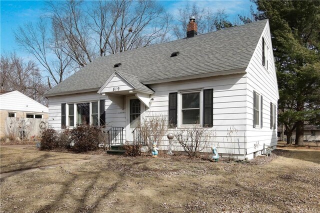view of front of house featuring roof with shingles and a chimney