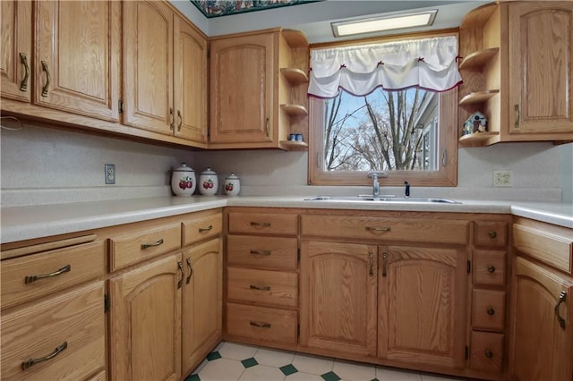 kitchen with light floors, open shelves, light countertops, and a sink