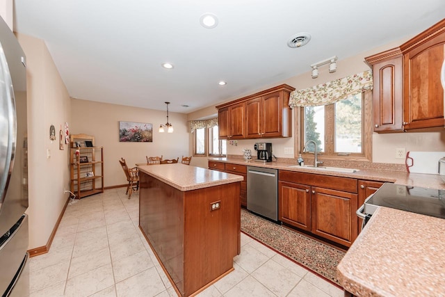 kitchen featuring visible vents, a sink, a center island, appliances with stainless steel finishes, and light countertops