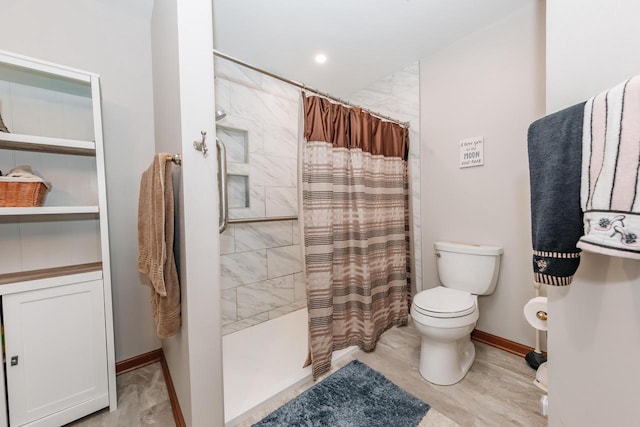 bathroom featuring baseboards, tiled shower, and toilet