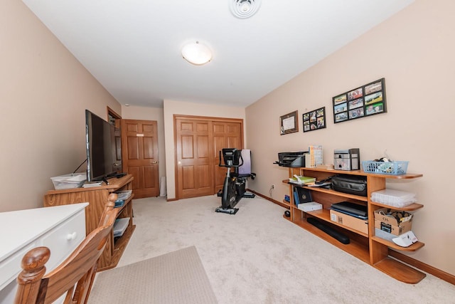 workout area with visible vents, baseboards, and light colored carpet