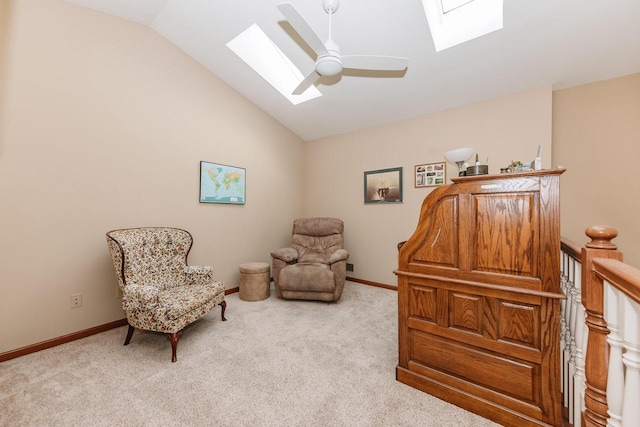 living area with lofted ceiling with skylight, baseboards, carpet floors, and ceiling fan