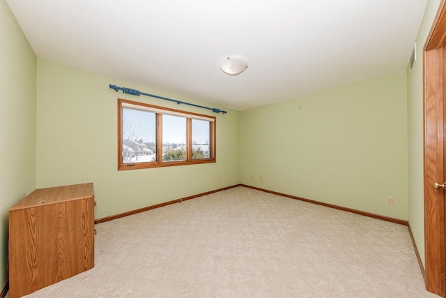 empty room featuring carpet flooring and baseboards