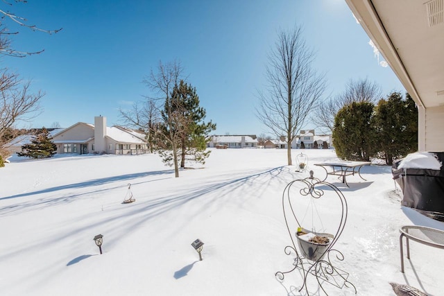 yard layered in snow with visible vents and a residential view