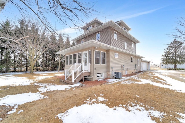 snow covered property with cooling unit, a garage, and a sunroom