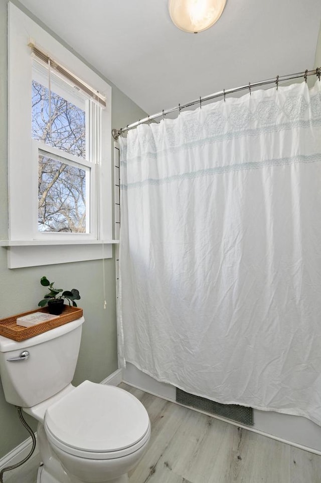 bathroom featuring a shower with curtain, baseboards, toilet, and wood finished floors