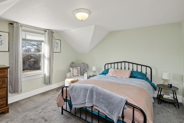 carpeted bedroom with vaulted ceiling and baseboards