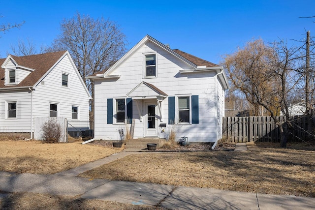 bungalow featuring a shingled roof and fence