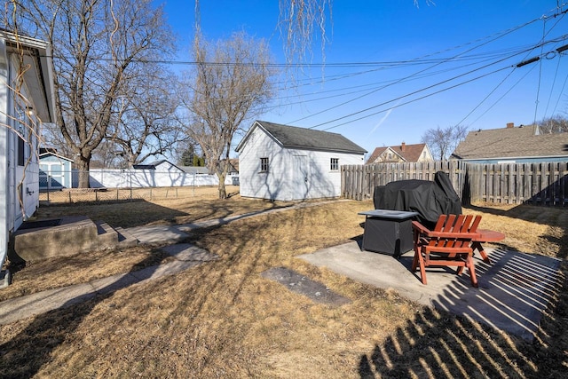 view of yard with an outbuilding, a fenced backyard, and a shed