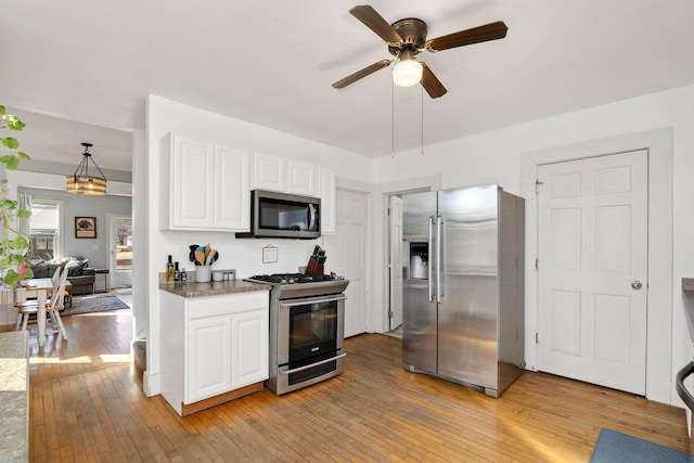 kitchen with light wood-style flooring, white cabinets, appliances with stainless steel finishes, and ceiling fan